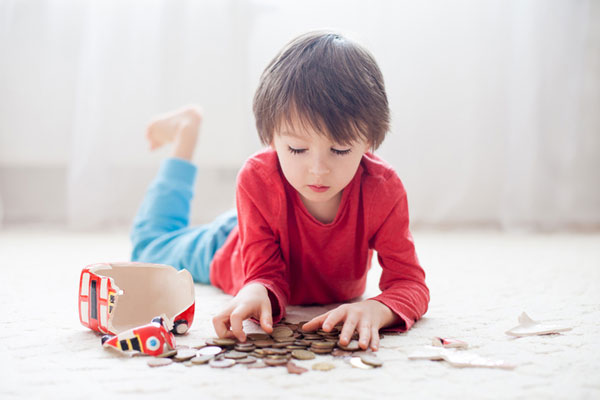 boy looking at pile of coins