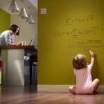 Successful baby doing algebra on hallway wall