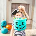 kid holding teal pumpkin filled with allergy free candy