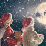 3 kids looking at Santa and his reindeer under moonlight sky.