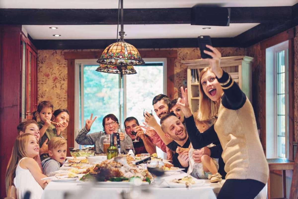 family taking selfie at thanksgiving dinner table