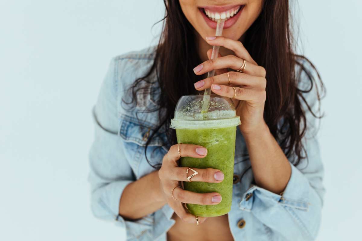 young woman drinking fresh juice smoothie