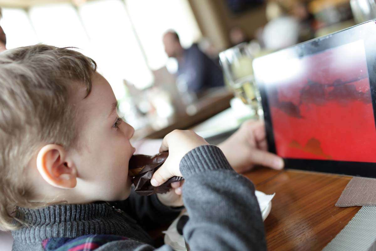 child using ipad while dining out