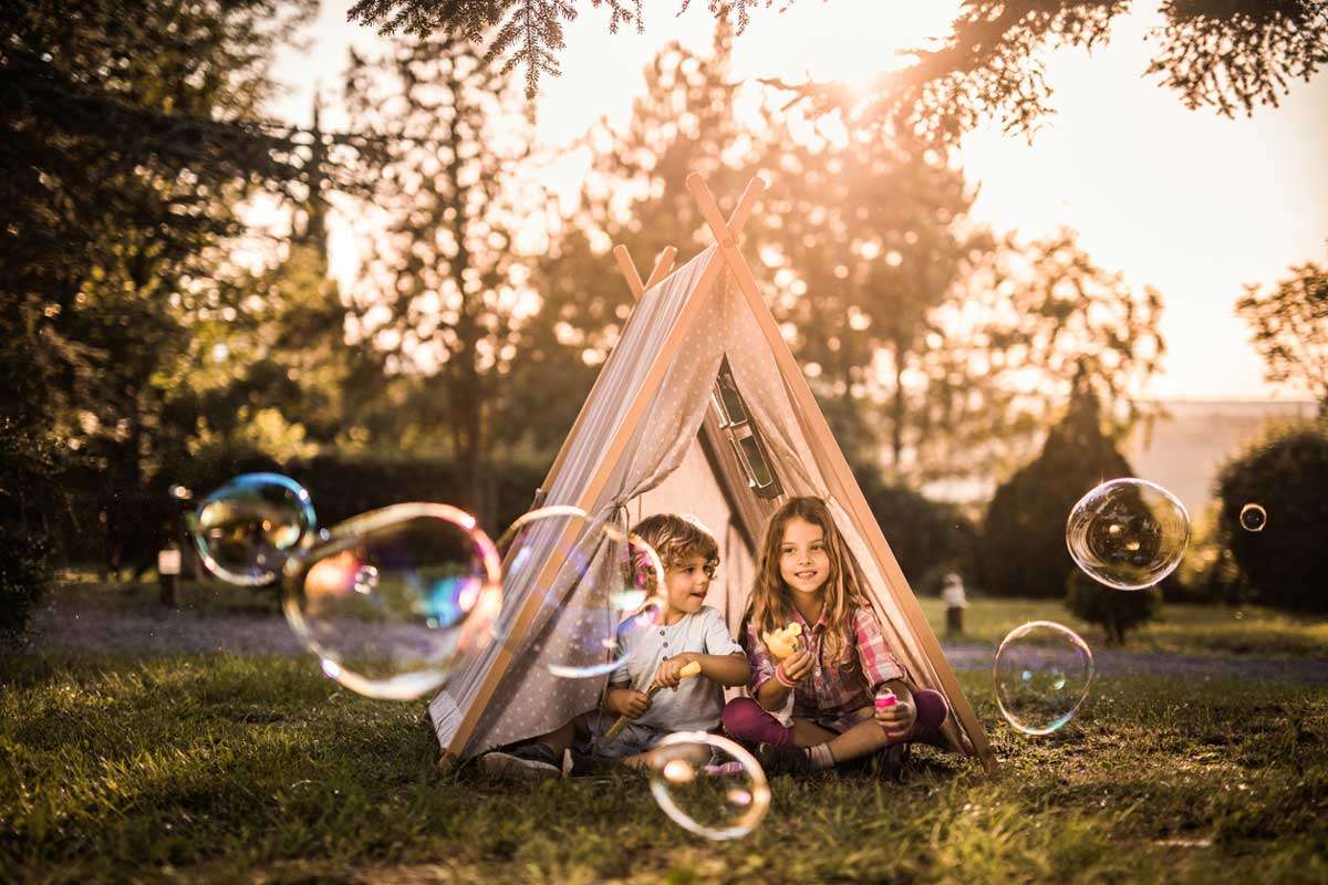kids playing with toys in tent in summer