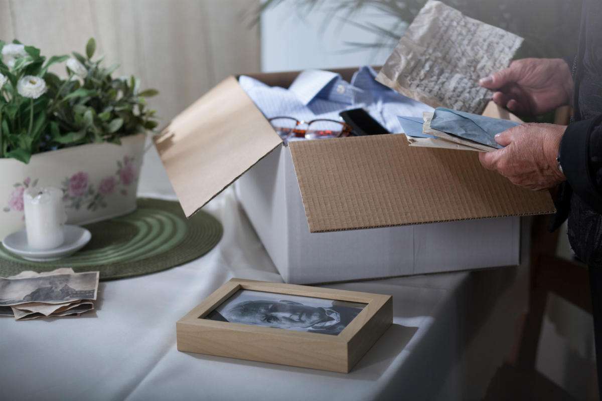 woman looking through box of family heirlooms to pass down