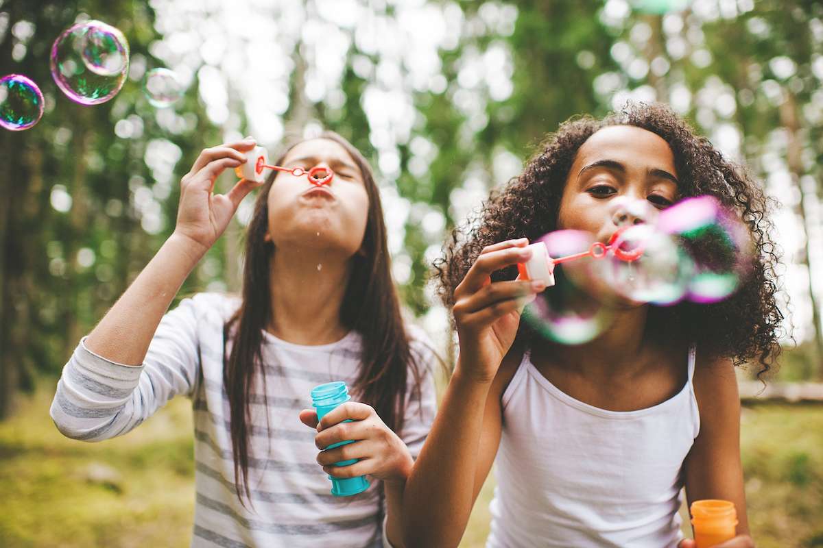 Two girls blowing with bubbles gifts