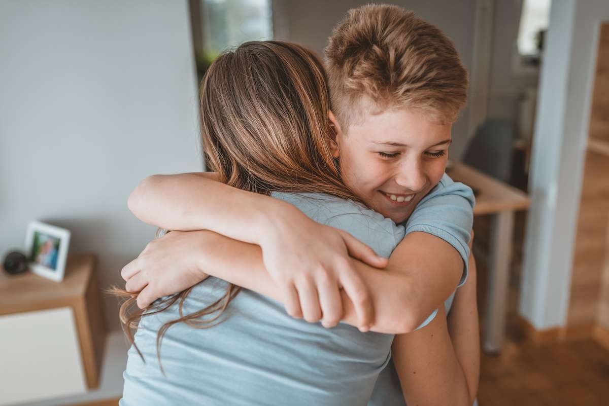 Happy 10 Year old boy embracing mom for giving him a gift