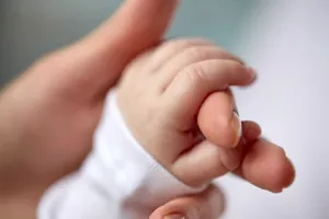 Newborn hand holding mother