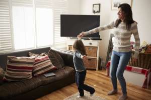 single mother and child dance in the living room