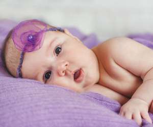 Little baby girl wrapped in purple blanket