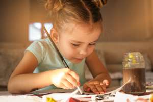 little girl stays busy doing crafts over school vacation