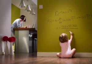 Successful baby doing algebra on hallway wall