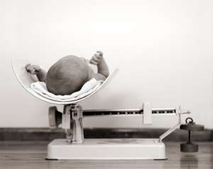 newborn baby being weighed on scale