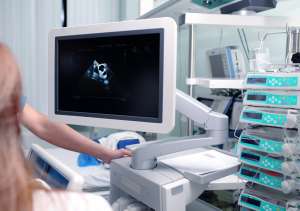 Medical specialists near ultrasound machine in the hospital ward