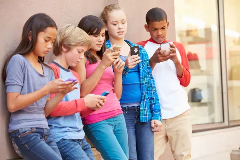 group of kids with smartphones vs. flip phones