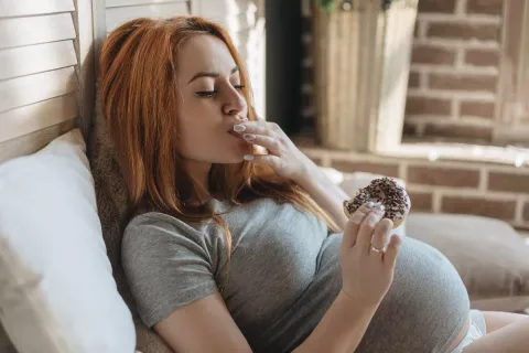 pregnant woman eating donut