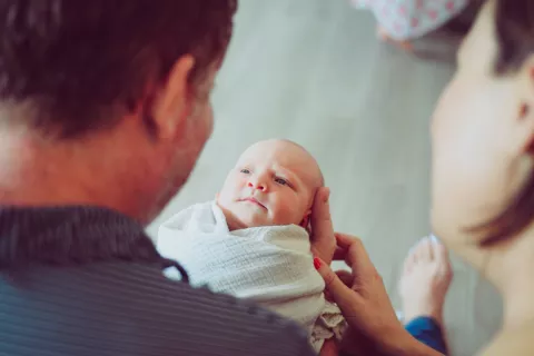 mom and dad looking at newborn, considering changing baby's name