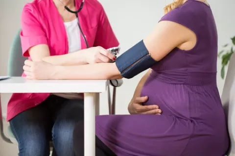 Image of a pregnant woman getting her blood pressure checked