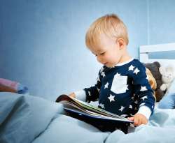 Child reading a book for hanukkah