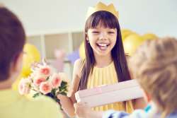 little girl enjoying birthday gifts and goodie bag