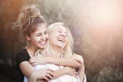 smiling adult daughter hugs mother