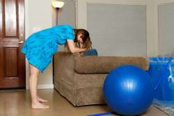 Pregnant woman leaning forward on couch