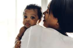 mother holding baby looking at camera