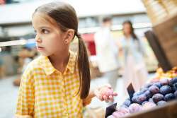 child stealing from fruit stall