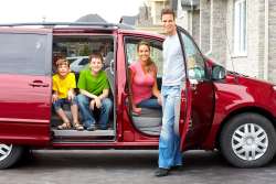 Tips for Road Trips and Car Travel with Kids, family of four ready for road trip in minivan