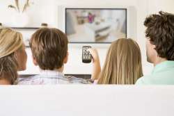 Back shot of family watching television together