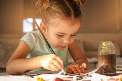 little girl stays busy doing crafts over school vacation
