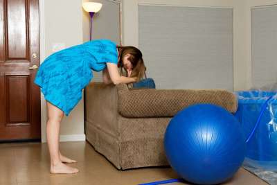 Pregnant woman leaning forward on couch