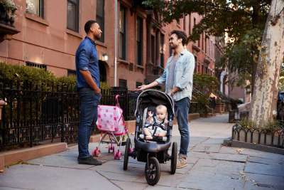 dad friends standing with strollers on street