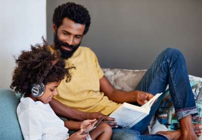 dad reading and son listening to audiobook