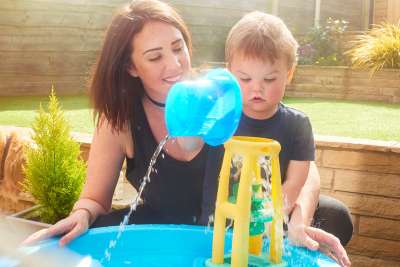 mom and son playing water table activity