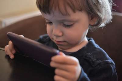 toddler using iphone at restaurant