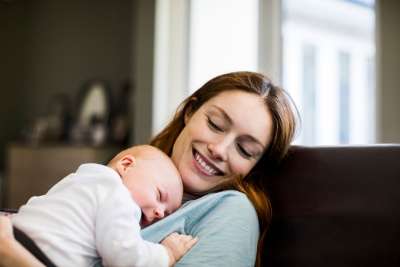Mom holding her bald baby