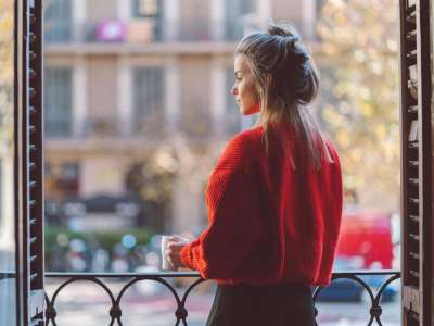 woman practicing mindfulness drinking coffee on balcony