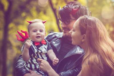 young couple taking baby trick or treating