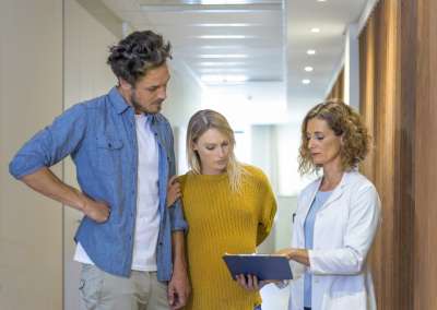 Mom and dad receiving genetic testing results from female doctor