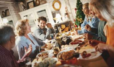 Family enjoying thanksgiving dinner and chatting about at their family tree and geneaology