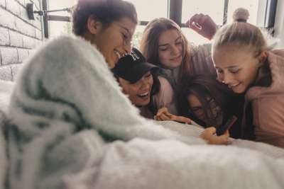 group of teen girls looking at phone at tiktok