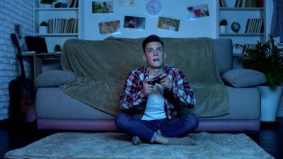 teen playing video games over winter break from college