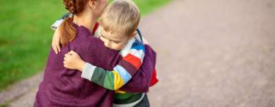 Mom hugging child going to school 