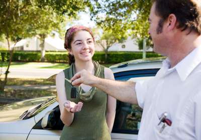 Dad giving teen daughter car keys 