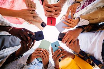 teenagers in a circle holding phones