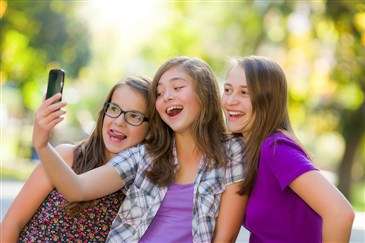 tween girls taking selfie with smartphone