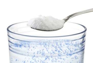 Spoon of Baking Soda Over Glass of Water