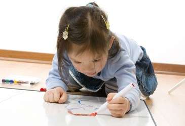 Young girl on floor painting picture
