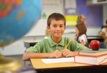 Young student sitting at desk smiling